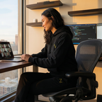 Person working at a desk with multiple monitors and a cityscape view