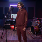 Person in a music studio with musical instruments and equipment.
