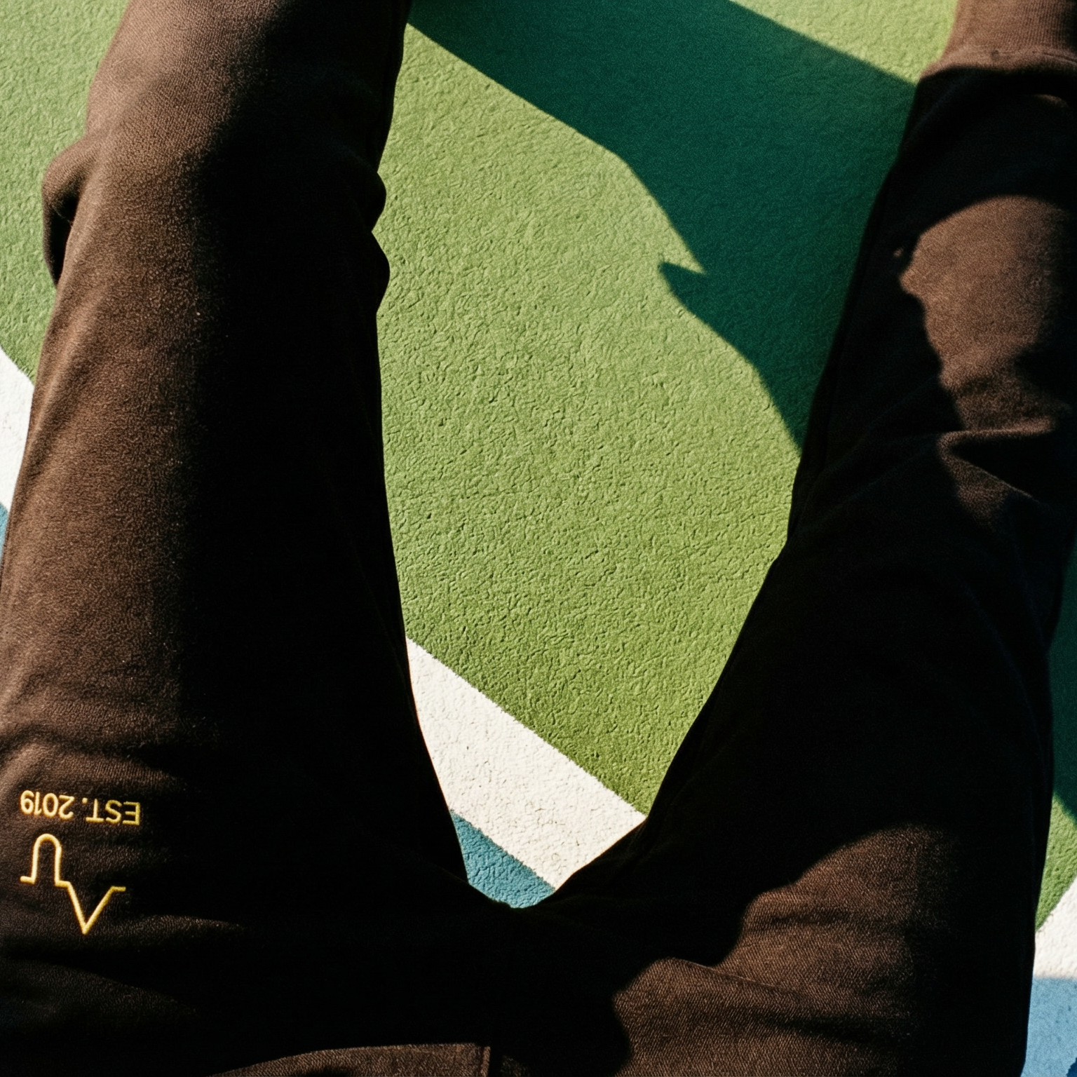 Brown pants with a brand logo on a sports court background