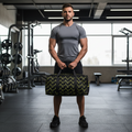 Man holding a black duffel bag with yellow patterns in a gym.