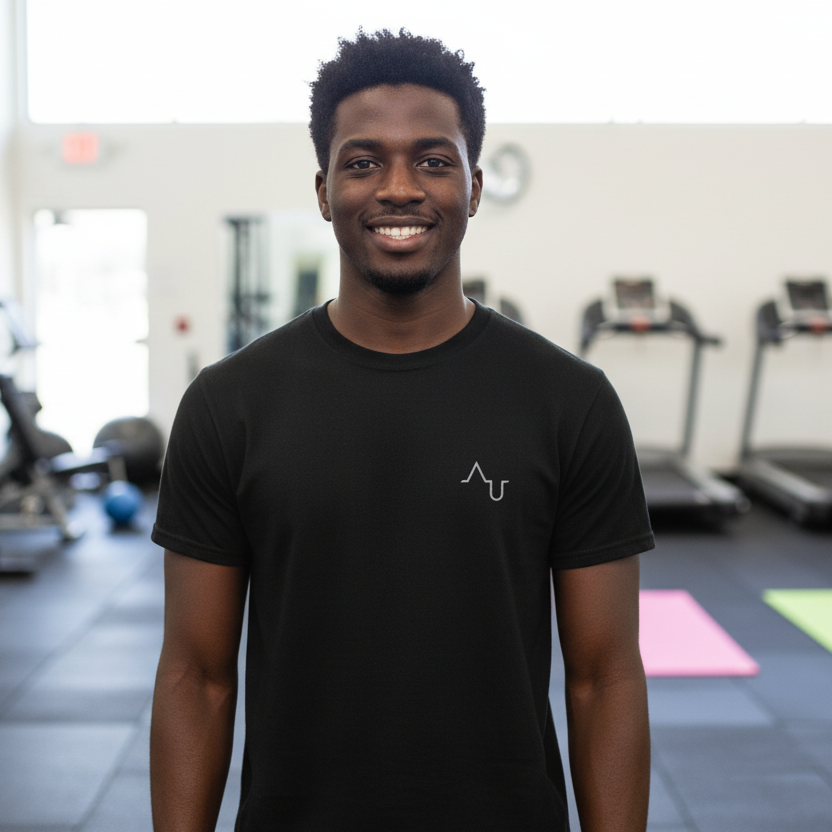 Man wearing a black t-shirt with a logo in a gym setting