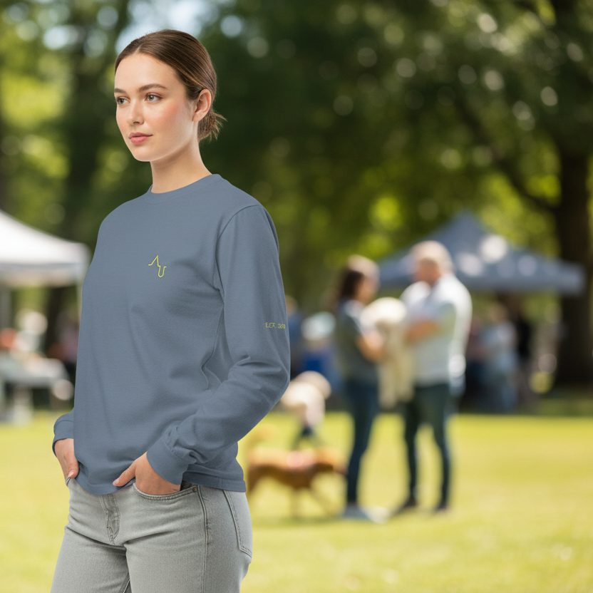 Woman wearing a gray long-sleeve shirt with a logo in a park setting