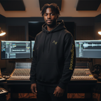 Person standing in a music production studio with equipment and screens.